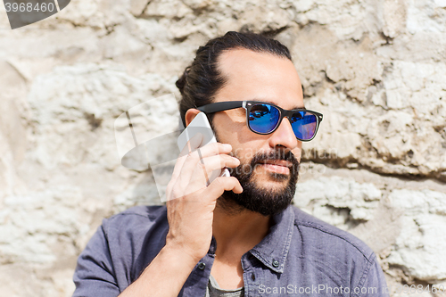 Image of man with smartphone calling on city street