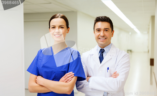 Image of smiling doctor in white coat and nurse at hospital