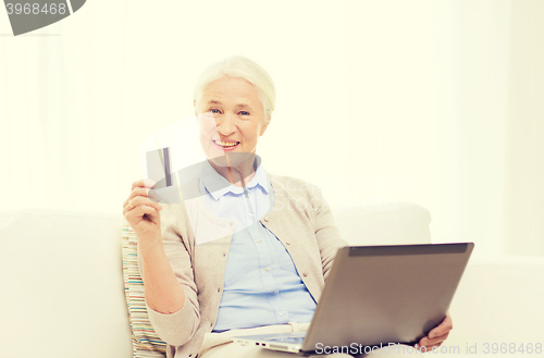 Image of senior woman with laptop and credit card at home