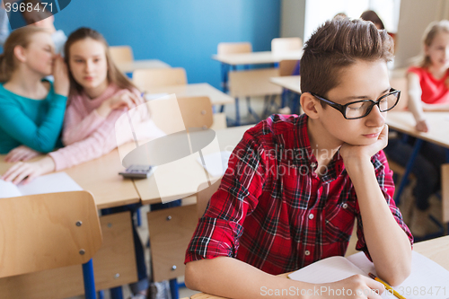 Image of students gossiping behind classmate back at school