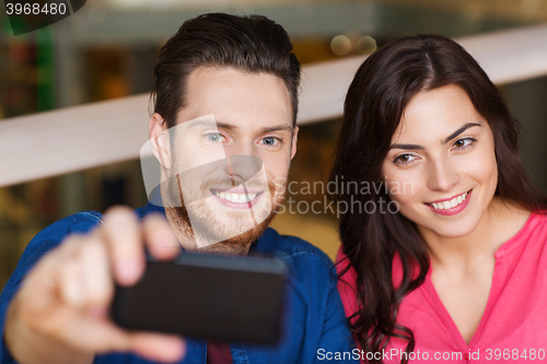 Image of couple taking selfie by smartphone at restaurant