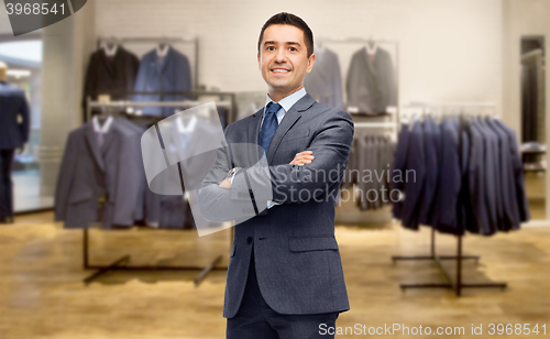 Image of happy businessman in suit over clothing store