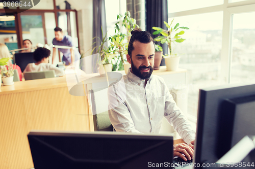 Image of happy creative male office worker with computer