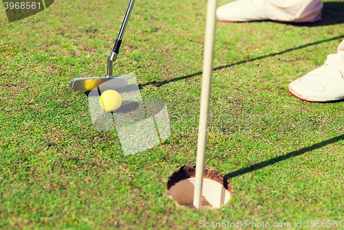 Image of close up of man with club and ball playing golf