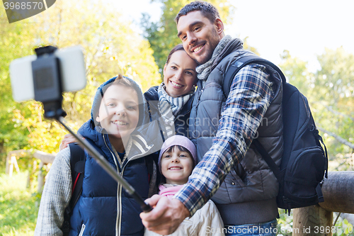 Image of family with backpacks taking selfie and hiking