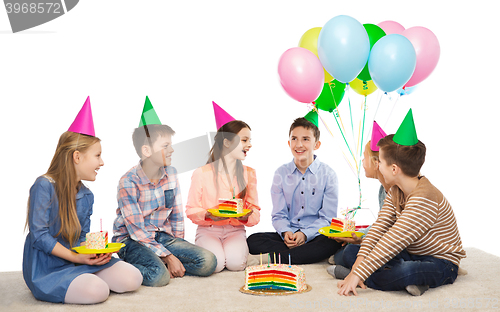 Image of happy children in party hats with birthday cake