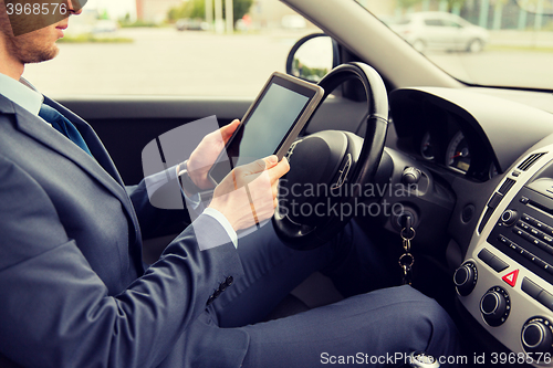 Image of close up of young man with tablet pc driving car