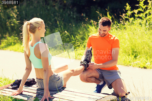 Image of happy couple with roller skates outdoors