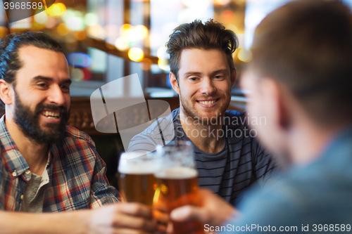 Image of happy male friends drinking beer at bar or pub