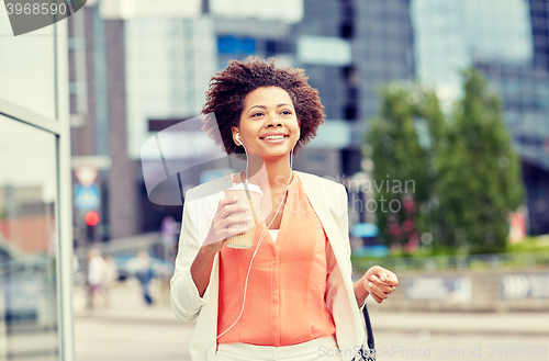 Image of happy african businesswoman with coffee in city