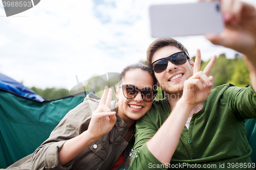 Image of couple of travelers taking selfie by smartphone
