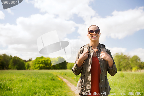 Image of happy young woman with backpack hiking outdoors