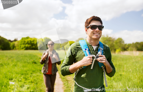 Image of happy couple with backpacks hiking outdoors