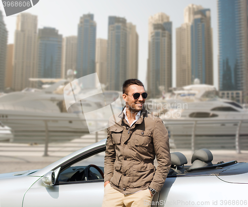 Image of happy man near cabriolet car on city