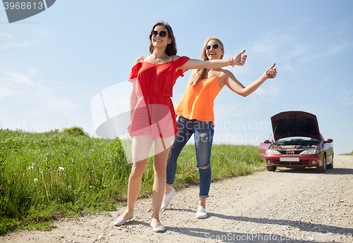 Image of women with broken car hitchhiking at countryside