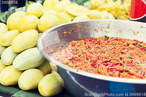 Image of chilly wok or pilaf and mango at street market