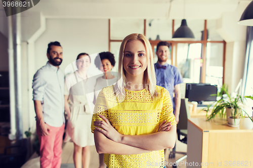 Image of happy young woman over creative team in office