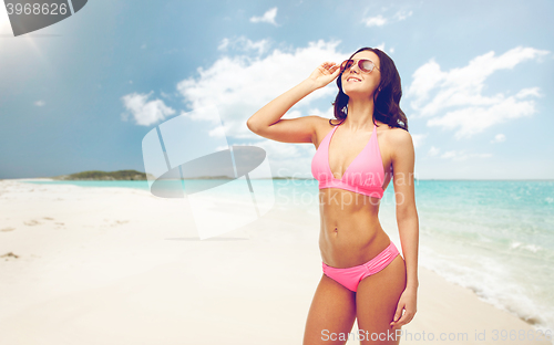 Image of happy woman in pink bikini swimsuit on beach