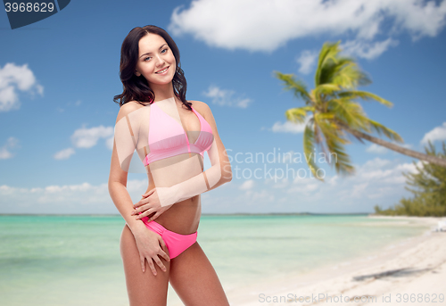 Image of happy young woman in pink bikini swimsuit