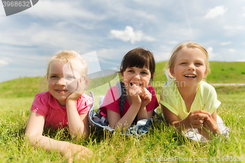 Image of group of kids lying on blanket or cover outdoors