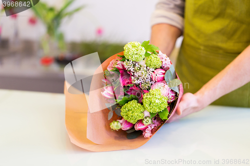 Image of florist wrapping flowers in paper at flower shop