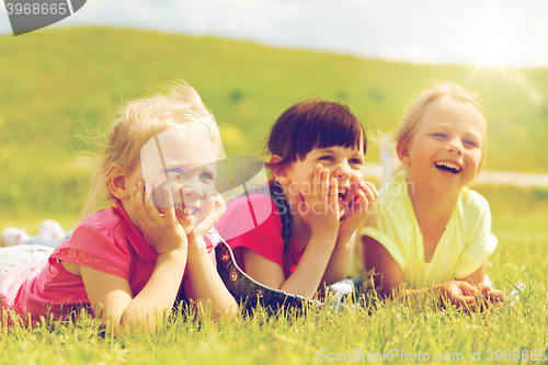 Image of group of kids lying on blanket or cover outdoors