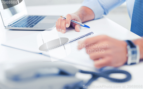 Image of businessman writing in notebook