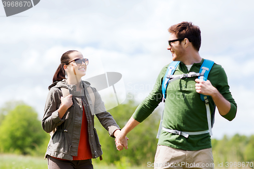 Image of happy couple with backpacks hiking outdoors