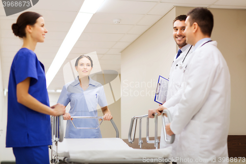 Image of group of happy doctors with gurney at hospital