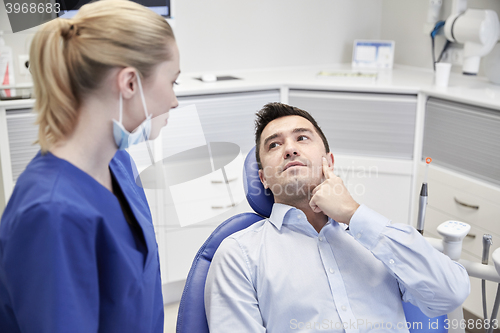 Image of male dentist with woman patient at clinic