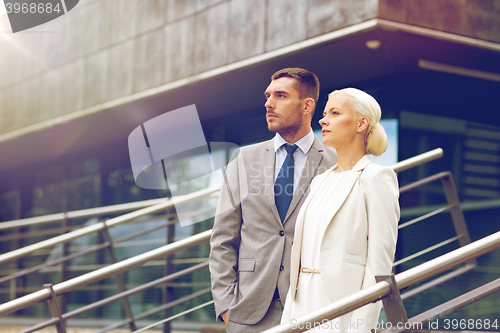 Image of serious businessmen standing over office building