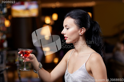 Image of glamorous woman with cocktail at night club or bar