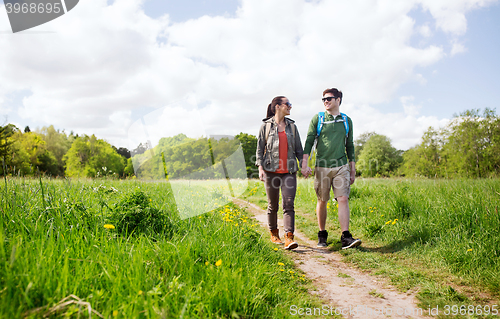 Image of happy couple with backpacks hiking outdoors