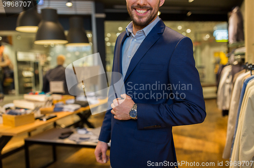 Image of close up of happy man in suit at clothing store