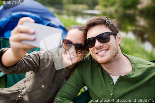 Image of couple of travelers taking selfie by smartphone