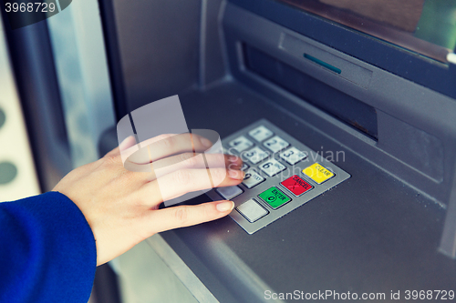 Image of close up of hand entering pin code at cash machine