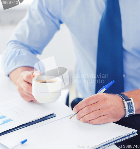 Image of businessman drinking coffee in office