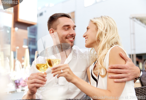 Image of happy couple drinking wine at open-air restaurant