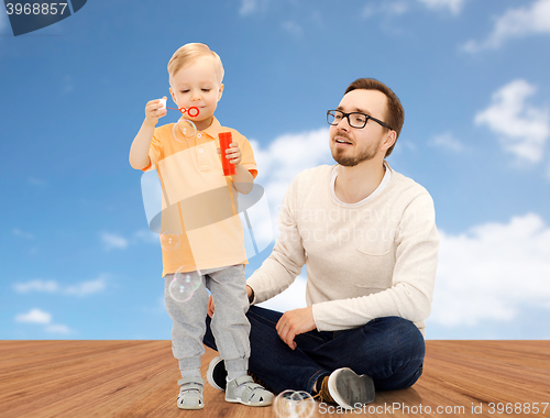 Image of father with son blowing bubbles and having fun