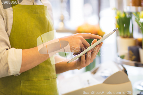 Image of close up of man with tablet pc at flower shop