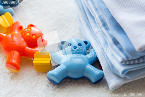 Image of close up of baby rattle and clothes for newborn