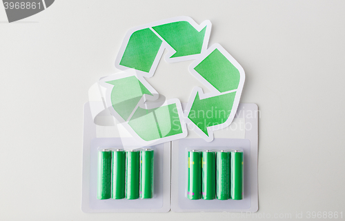 Image of close up of batteries and green recycling symbol