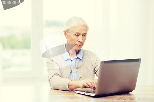 Image of senior woman with laptop at home