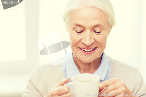 Image of happy senior woman with cup of tea or coffee