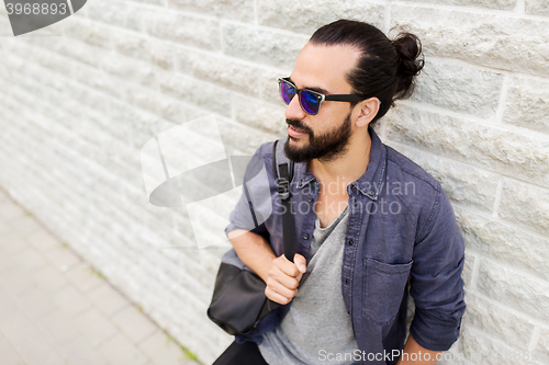 Image of man with backpack standing at city street wall