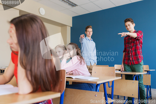 Image of students gossiping behind classmate back at school