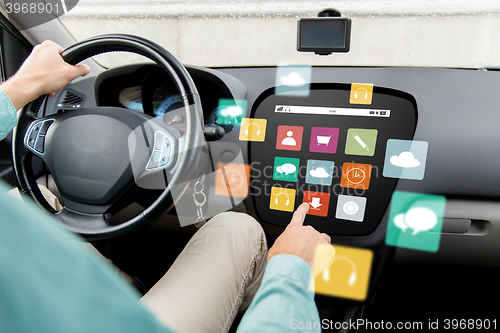 Image of man driving car with menu icons on board computer