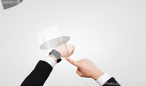 Image of businessman pointing to smart watch at his hand