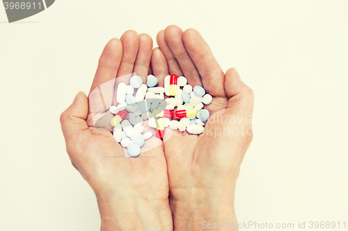 Image of close up of senior woman hands with pills
