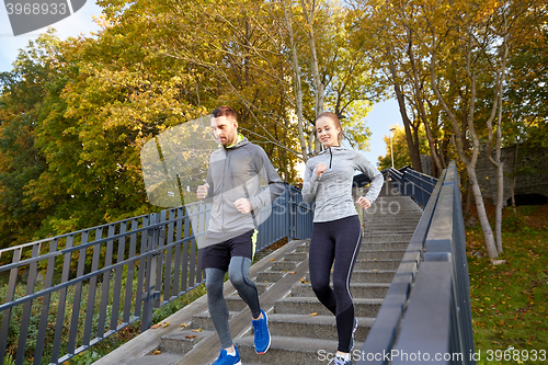 Image of happy couple running downstairs in city